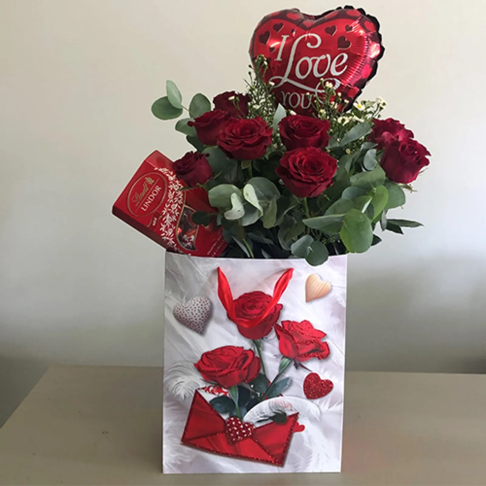 Valentine gift bag with red roses, eucalyptus, an 'I Love You' balloon and Lindor chocolates