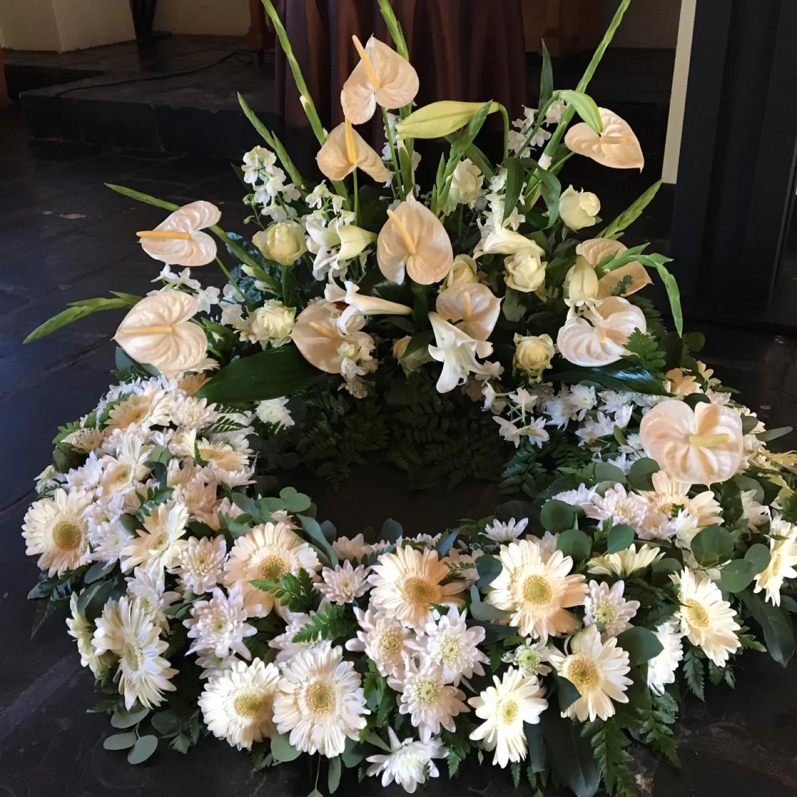 Cream and white wreath of gerberas and chrysanthemums with a raised anthurium spray
